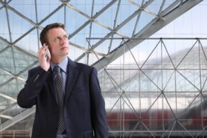 ETF Sectoranalyse - Zakenman aan de telefoon onder glazen dak — symbool voor beslissen met overzicht